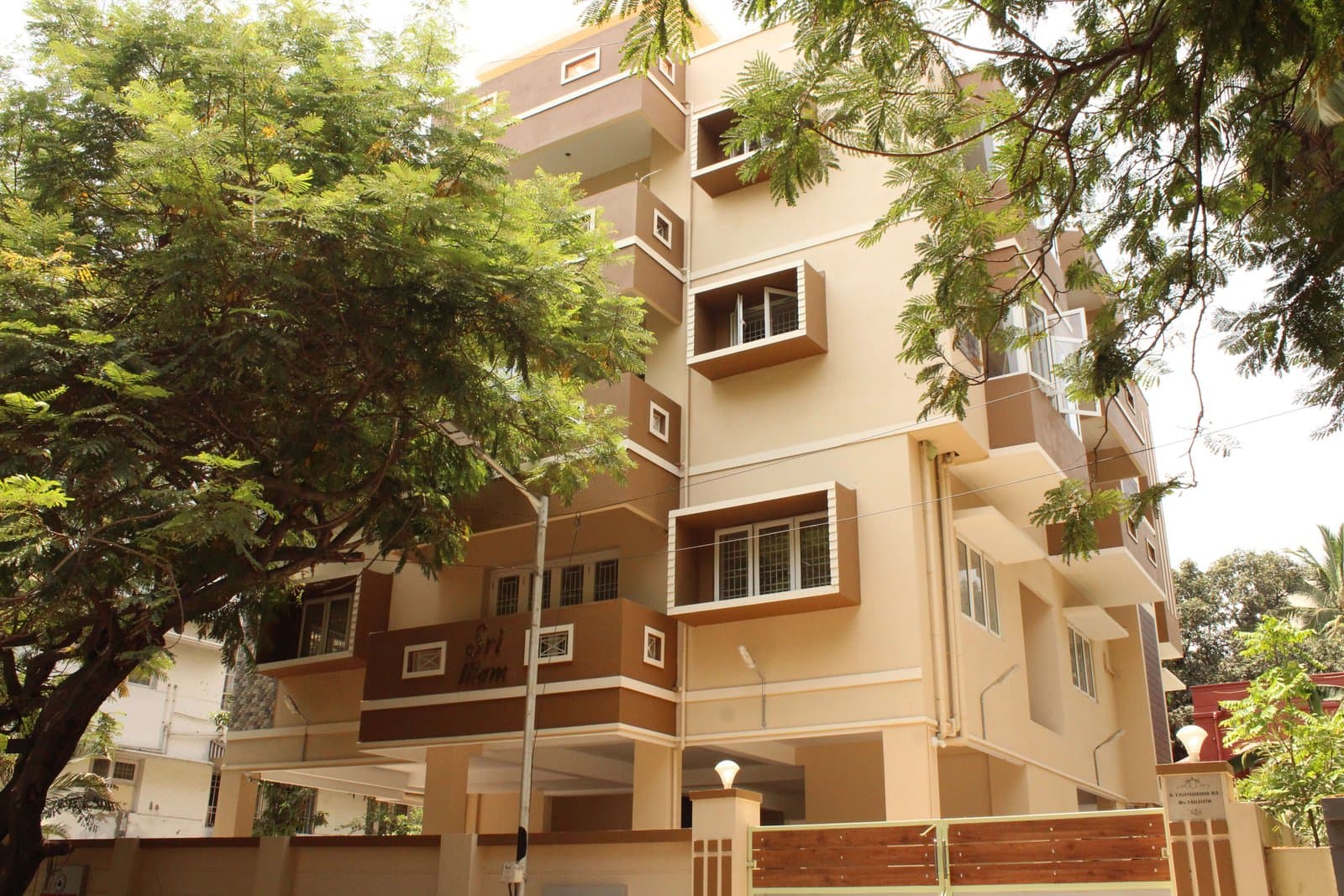 The Sri Illam apartment building on Thirumoorthy Street seen through the branches of a tree